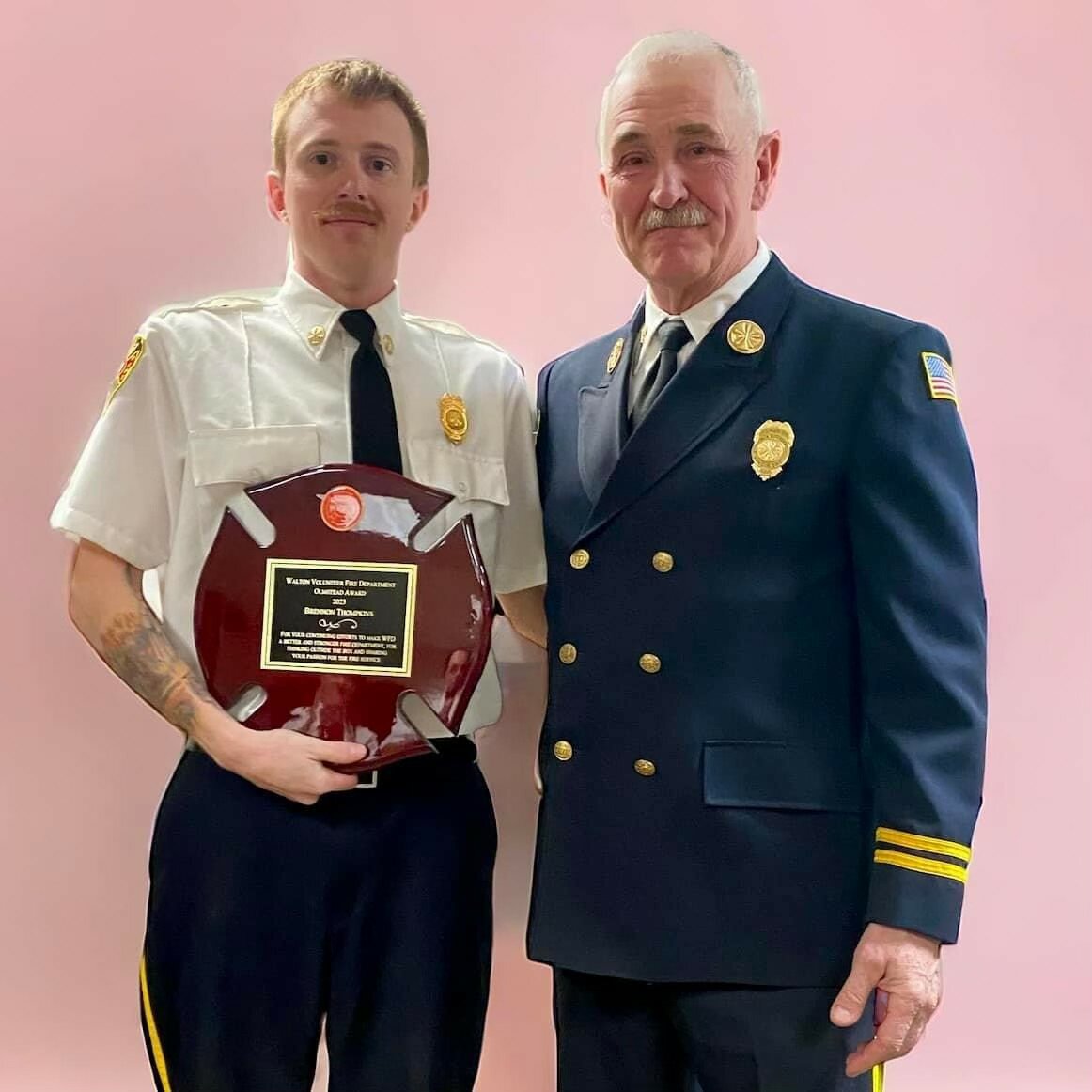 Walton Fire Chief Bob Brown, right, presents Brennon Tompkins with the 2023 Olmstead Award.
